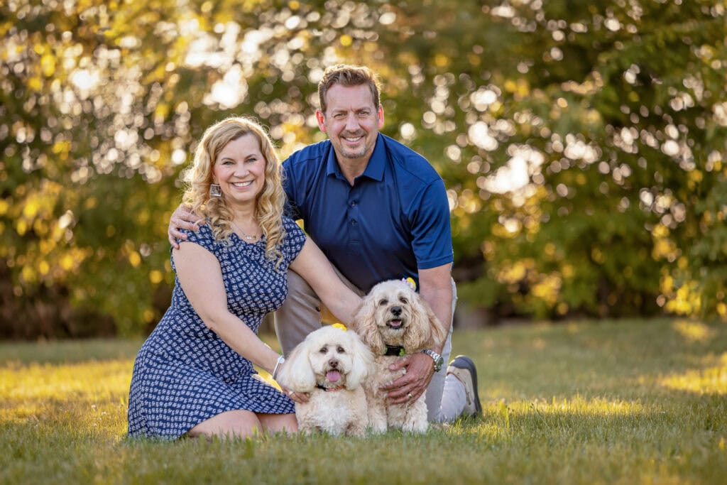 woman and a man with two small dogs sitting on grass  at Peller Estates Winery in Niagara on the Lake