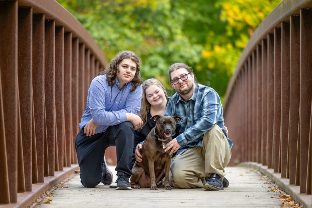 A young girl, two boys sitting on a bridge with their dog at Balls Falls Conservation Area 