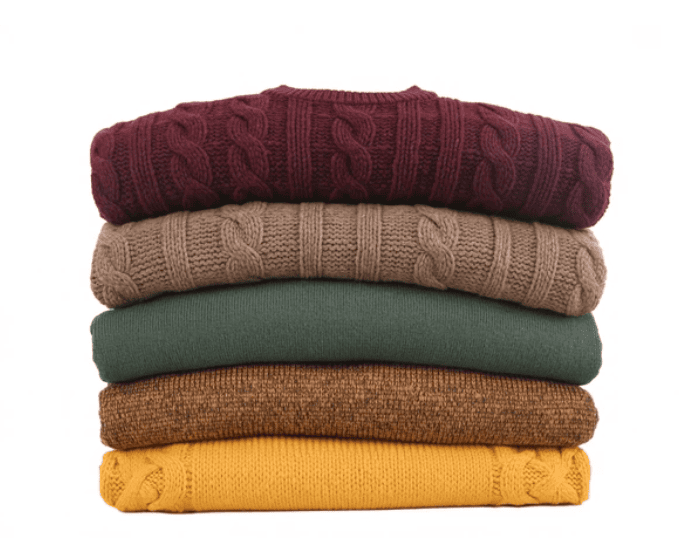 Stack of jewel toned sweaters to give people ideas as to what to wear for their dog photoshoot in Niagara on the Lake