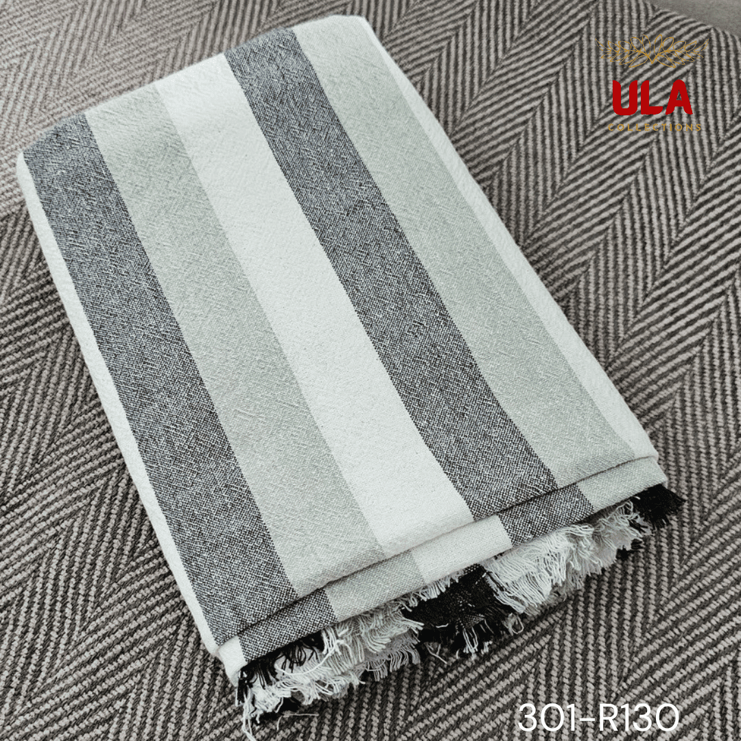 A close-up view of a soft woven throw blanket or textile featuring a bold vertical stripe pattern in a neutral and muted color scheme of charcoal gray, light sage green, and off-white.