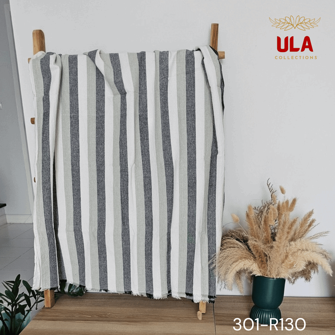 A close-up view of a soft woven throw blanket or textile featuring a bold vertical stripe pattern in a neutral and muted color scheme of charcoal gray, light sage green, and off-white.