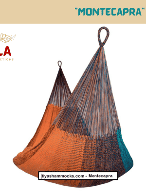 Woven net hammock chair, "Montecapra" pattern, combining deep, earthy tones of terracotta orange, dark blue, and teal in a woven net.
