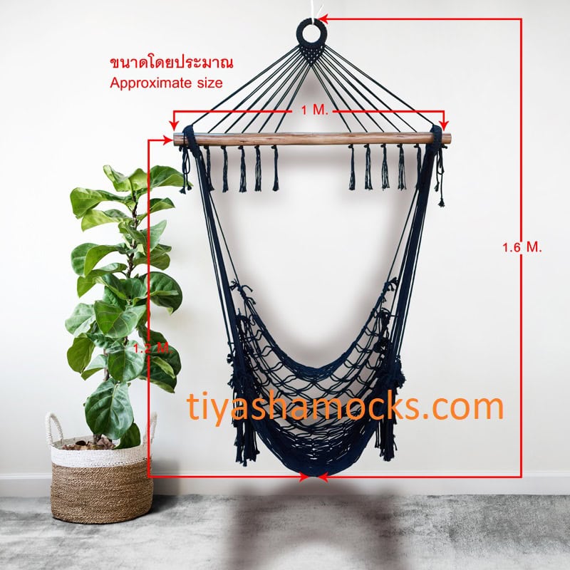 black macrame hanging chair with wooden spreader bar. Shows approximate size: Width 1 M, Height 1.6 M. Modern minimalist decor with a fiddle leaf fig plant.