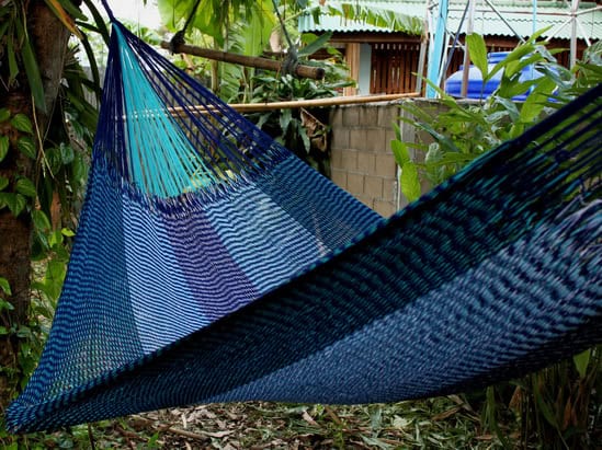 Woven net hammock chair, "Shade of Blue" pattern, featuring a striking color gradient from dark navy blue to medium blue and light turquoise, ideal for coastal or aquatic themes.