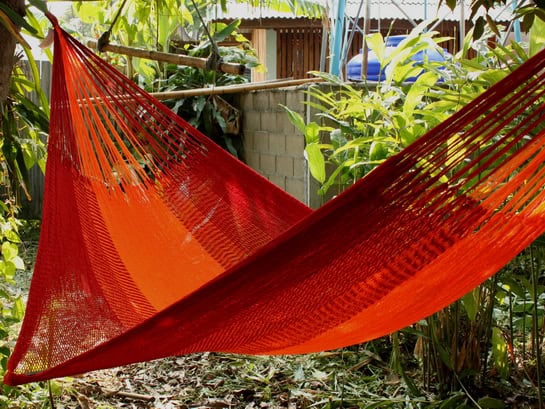 Two-tone red and orange hammock, isolated product shot, ideal for a bright outdoor space.