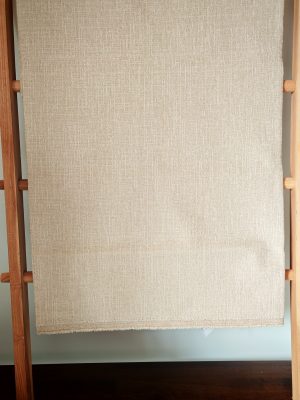Close-up showing the texture of thick cotton linen fabric in a natural beige or light brown color.
