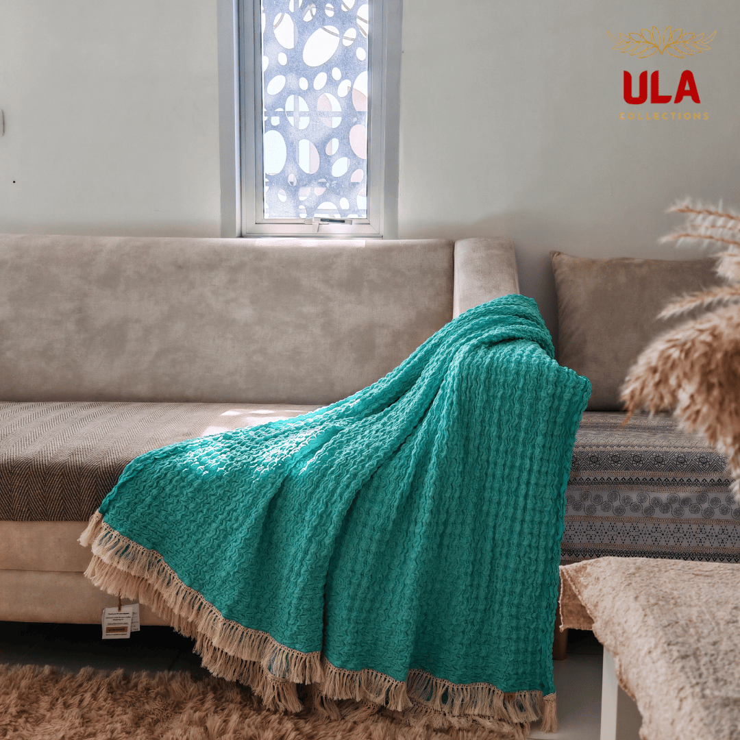 Turquoise Ruffle waffle throw blanket elegantly draped over a couch corner, stylish pop of color for modern home interiors by ULA Collections.