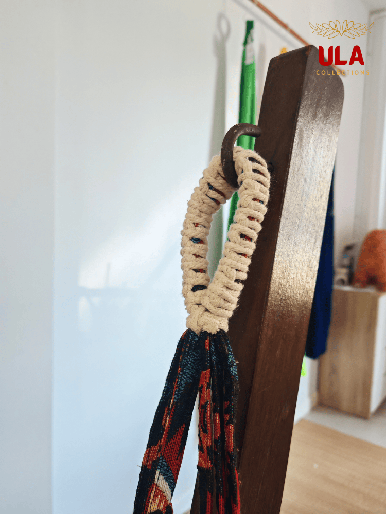 Close-up of hammock chair loop, showing the durable cream macramé reinforcement and colorful woven fabric hanging from a metal hook.