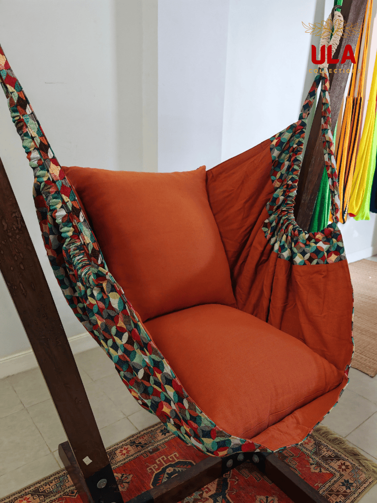 Vibrant woven fabric hammock chair featuring the Canyon multicolored overlapping circle pattern and plush orange cushions.