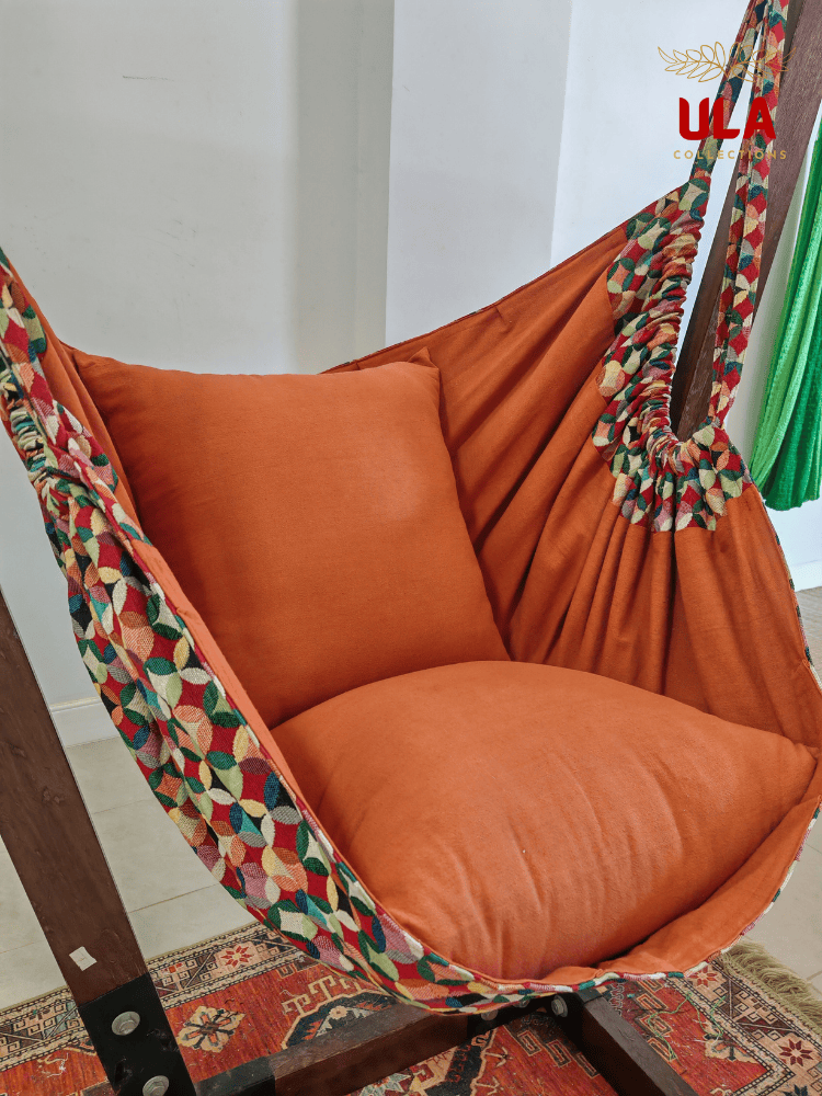 Vibrant woven fabric hammock chair featuring the Canyon multicolored overlapping circle pattern and plush orange cushions.