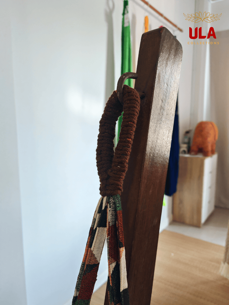 Close-up of hammock chair loop, showing the durable brown macramé reinforcement and colorful woven fabric hanging from a metal hook.