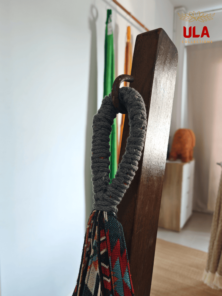 Close-up of hammock chair loop, showing the durable grey macramé reinforcement and colorful woven fabric hanging from a metal hook.