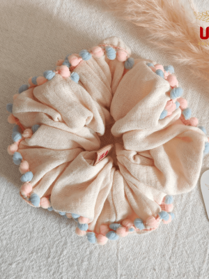 cream color with blue-pink pom pom trim scrunchie