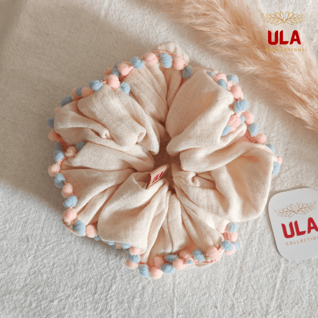 cream color with blue-pink pom pom trim scrunchie