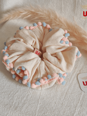 cream color with blue-pink pom pom trim scrunchie