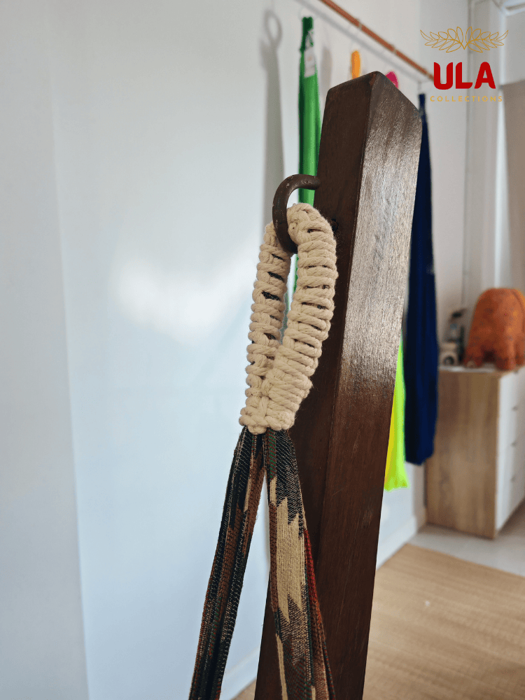 Close-up of hammock chair loop, showing the durable cream macramé reinforcement and colorful woven fabric hanging from a metal hook.
