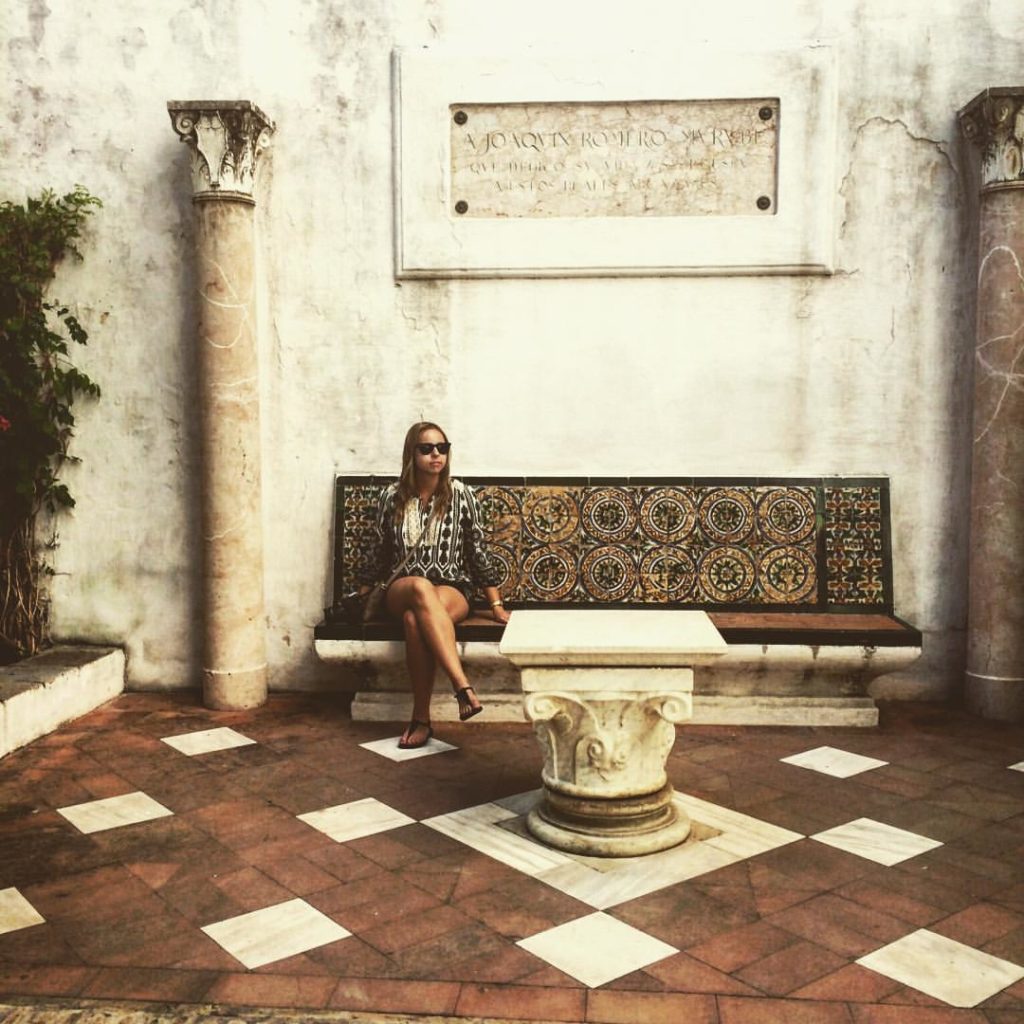 Woman sitting on a bench at the Real Alcázar in Sevilla, Spain