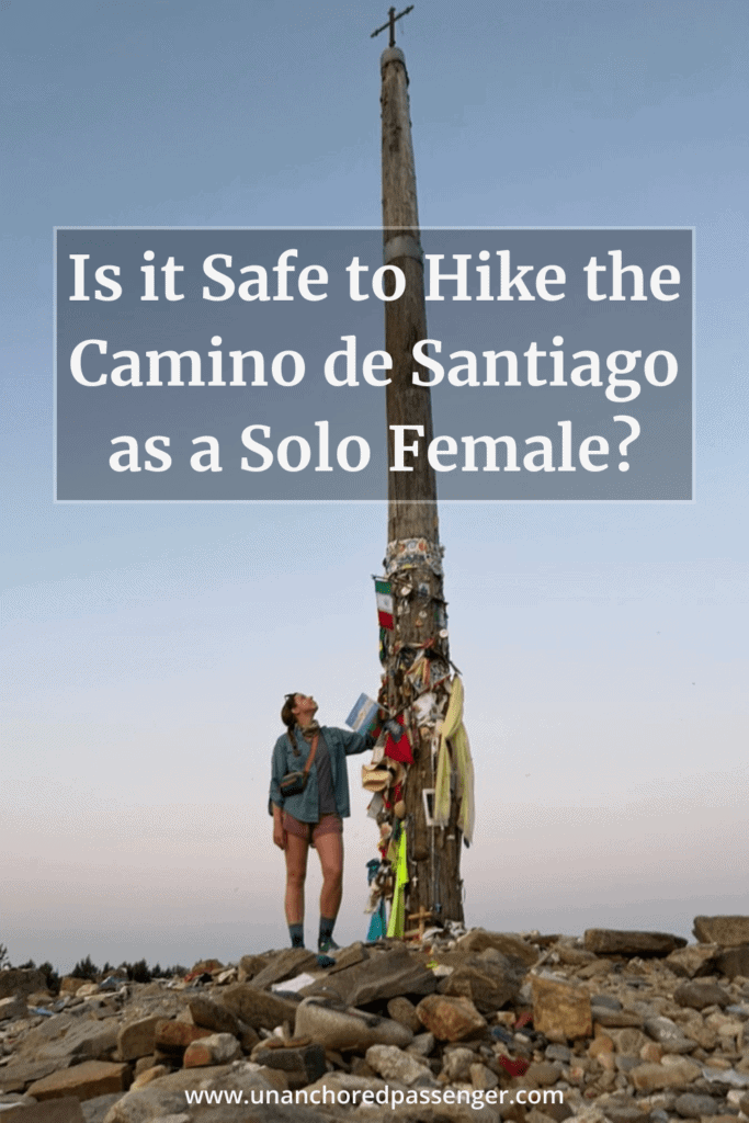 Hiker staring up at a tall cross at sunrise with text that says, "Is it Safe to Hike the Camino de Santiago as a Solo Female?"