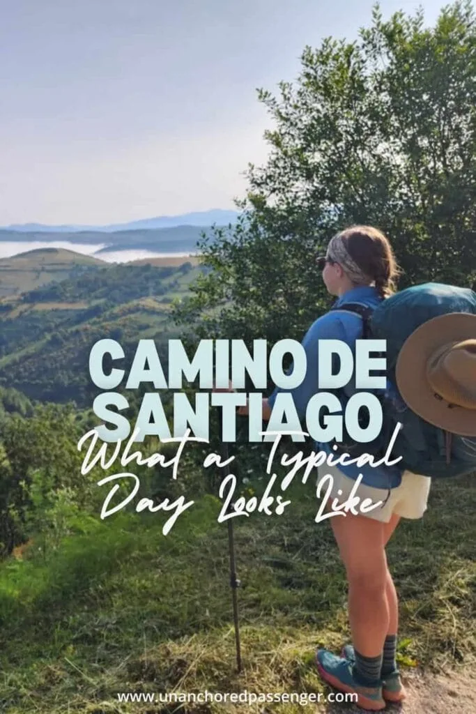 Female hiker looking down over a mountain valley below with text that says "Camino de Santiago What a Typical Day Looks Like"