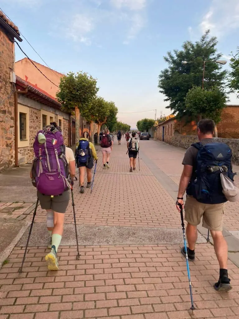 Several hikers walking down a road along the Camino Francés route of the Camino de Santiago