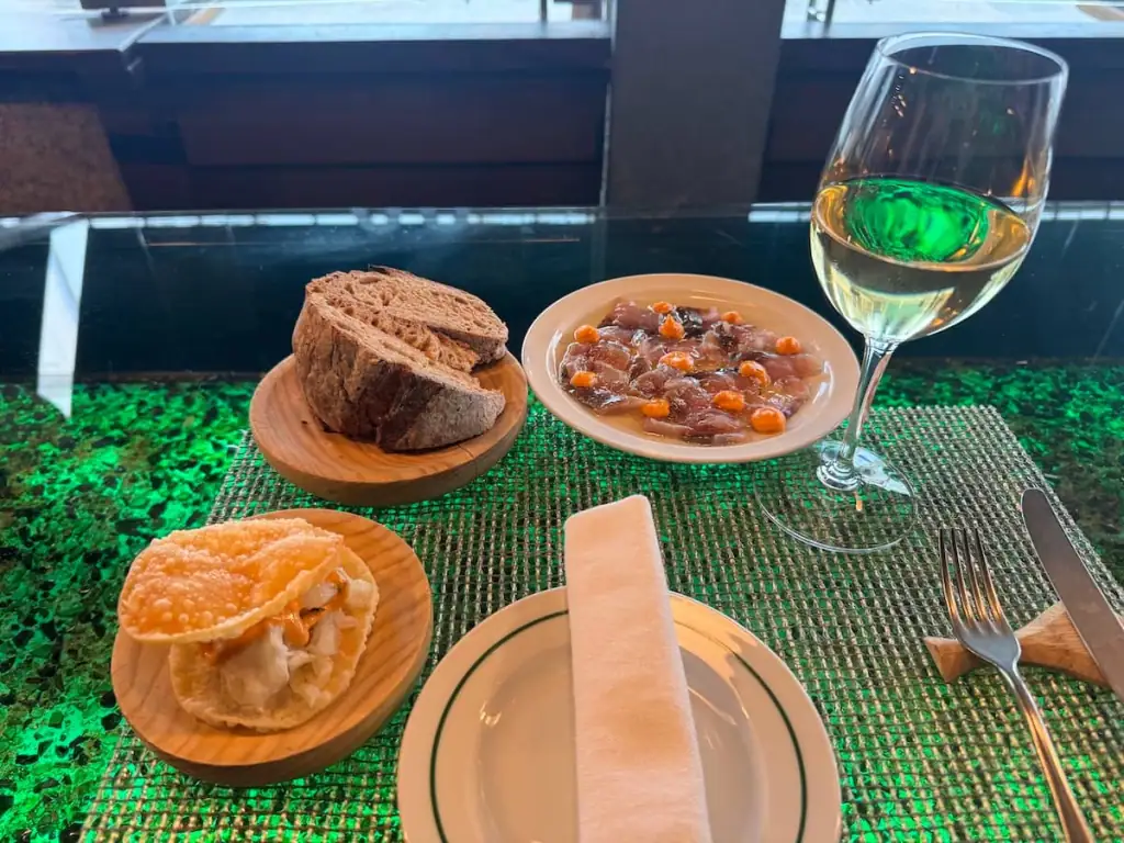 Small plates of food and a glass of white wine at Abastos 2.0 in Santiago de Compostela, Spain.