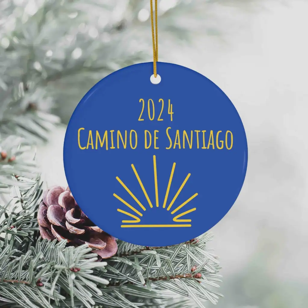 Blue Christmas ornament that says "2024 Camino de Santiago" and shows the scallop shell symbol.