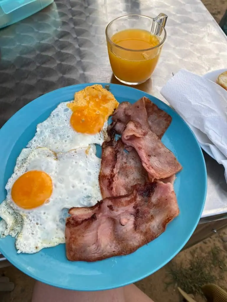 Bacon, eggs, and orange juice on a plate at a stop along the Camino Francés.