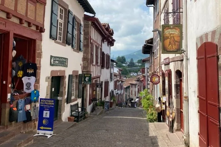 Narrow cobblestone streets of Saint-Jean-Pied-de-Port, France with a Camino de Santiago sign