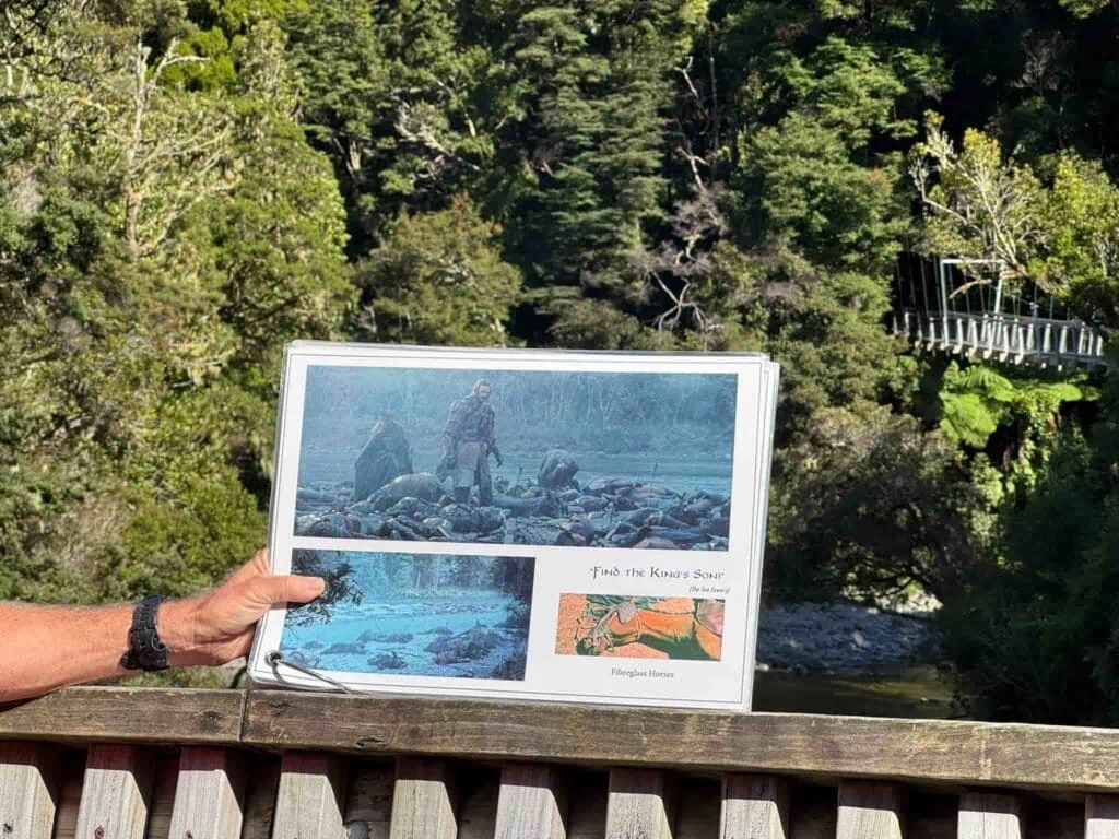 Hand holding up a paper with images from The Lord of the Rings scene where they find King Théoden's son fallen in battle.