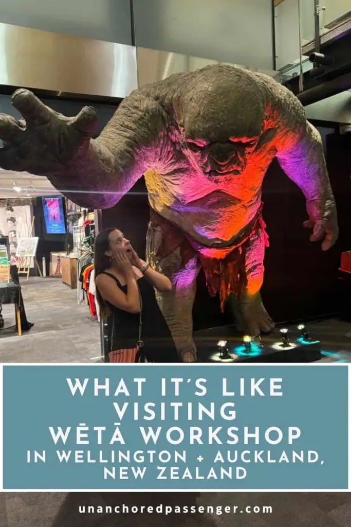 Image of Mikala pretending to be scared in front of a large troll statue at Wētā Workshop Unleashed in Auckland, New Zealand with text that says, "What It's Like Visiting Wētā Workshop in Wellington + Auckland, New Zealand"