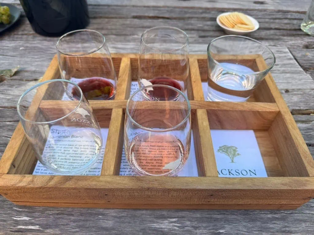 Tray with four glasses of wine and a glass of water at Jackson Estate winery in Blenheim, New Zealand.