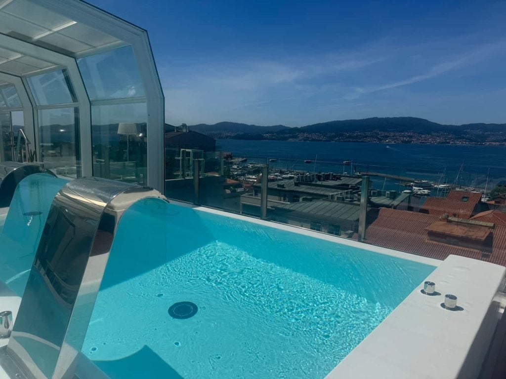 Pool spa overlooking Vigo, the water, and mountains in the distance on a sunny day at the Hotel Gran Nagari along the Camino Portugués Coastal route.