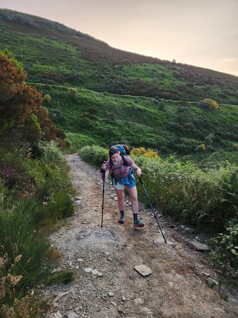 Mikala struggling up a steep mountain incline while hiking along the Camino Francés.
