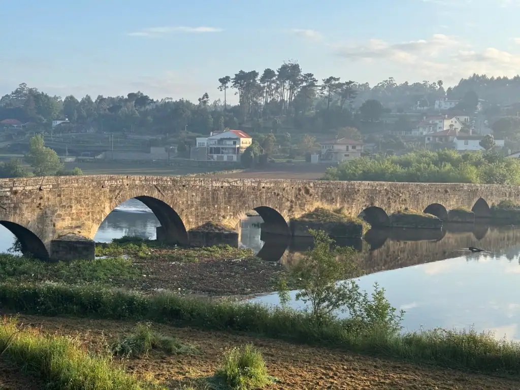 Puente de Ave bridge crossing over a river on the Camino Portugués Central route in the early morning light.