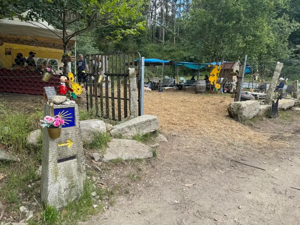 Clearing in the forest filled with tents and pilgrims at A Parada do Camiño, where they sell some drinks and snacks.