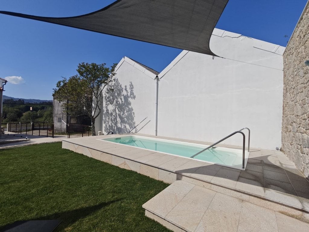 Grassy courtyard with a pool at Villa Vieira in A Escravitude along the Camino Portugués.
