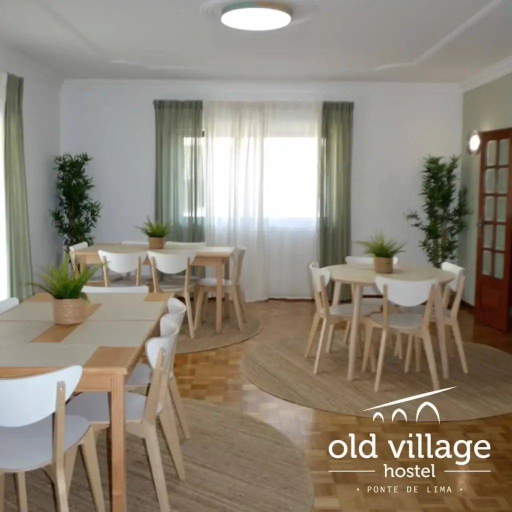 Common area with several tables and chairs at Old Village Hostel along the Camino Portugués Central route in Ponte de Lima.