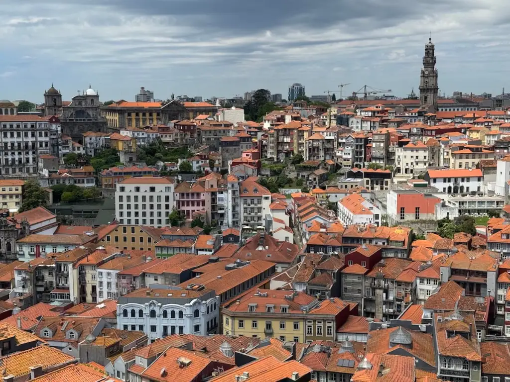 Overhead view of dozens of orange rooftops and a church tower in Porto, taken from a tower at Sé Cathedral.