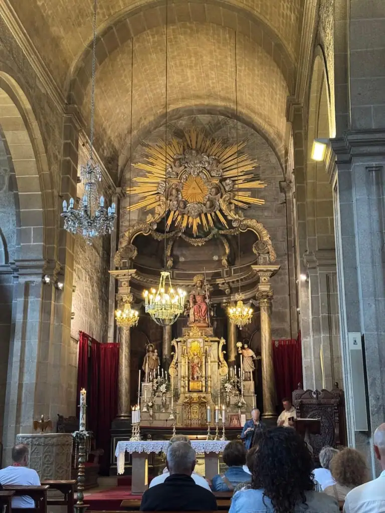 Altar at the main church in Padrón with people sitting the pews and mass about to start.