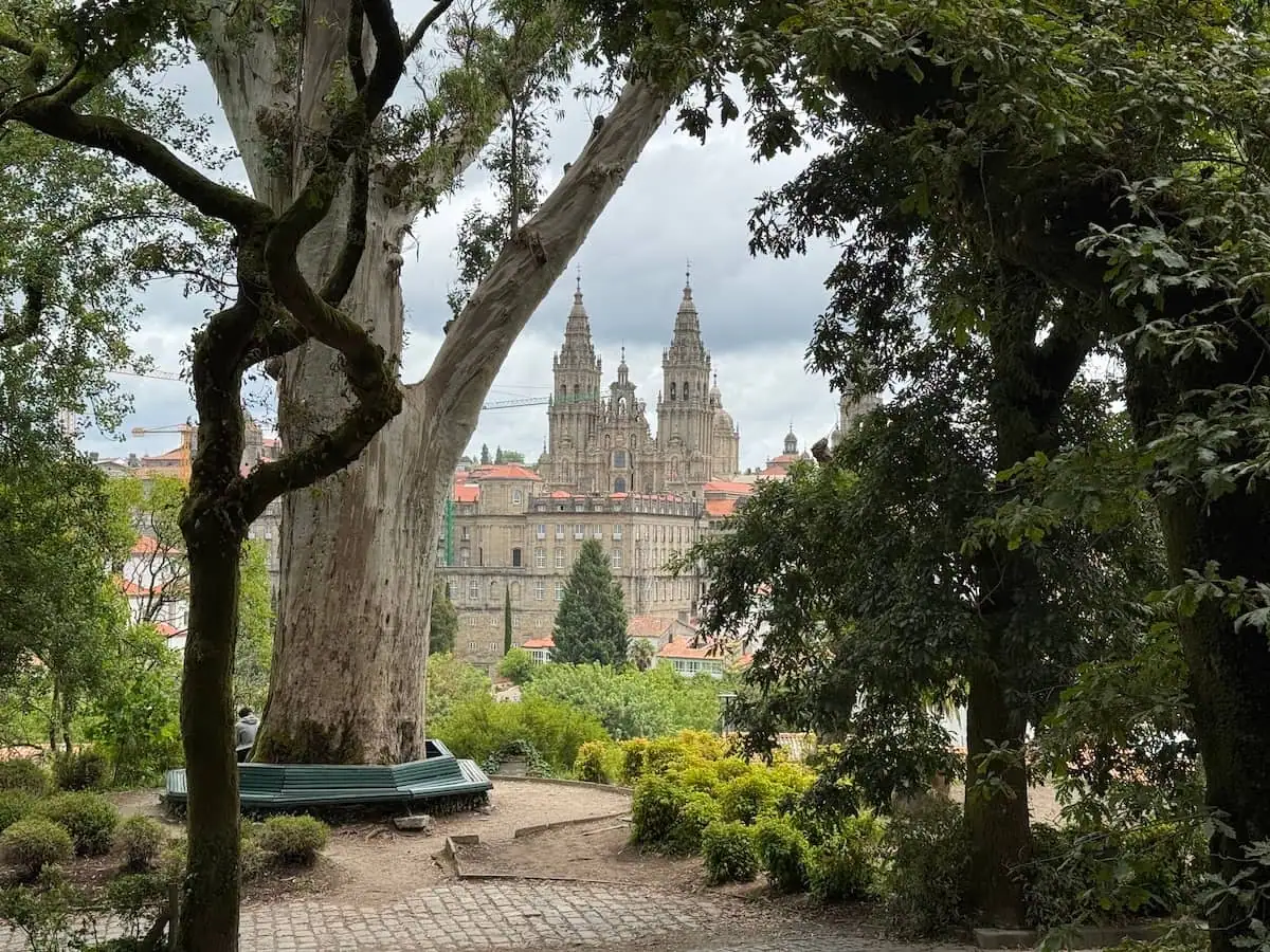 View of the cathedral in Santiago de Compostela, Spain through the trees in a park.