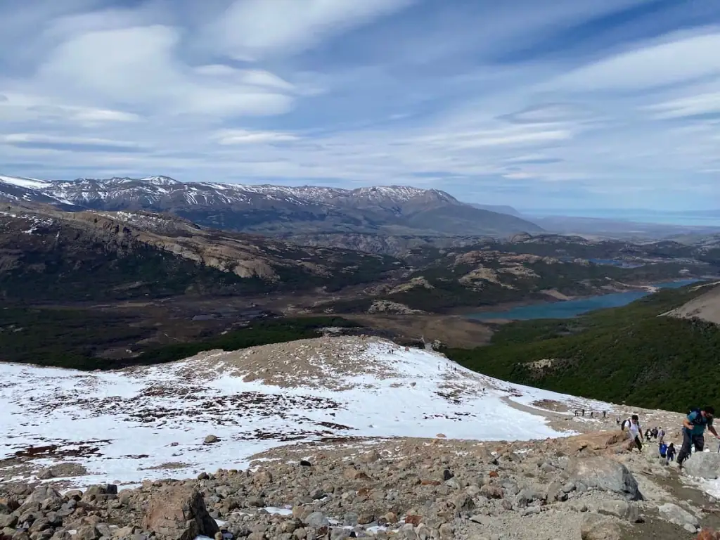Sweeping view from the end of the Mount Fitz Roy hike in El Chaltén in Patagonia, looking down over rocky terrain, green valleys, and glacial lakes.