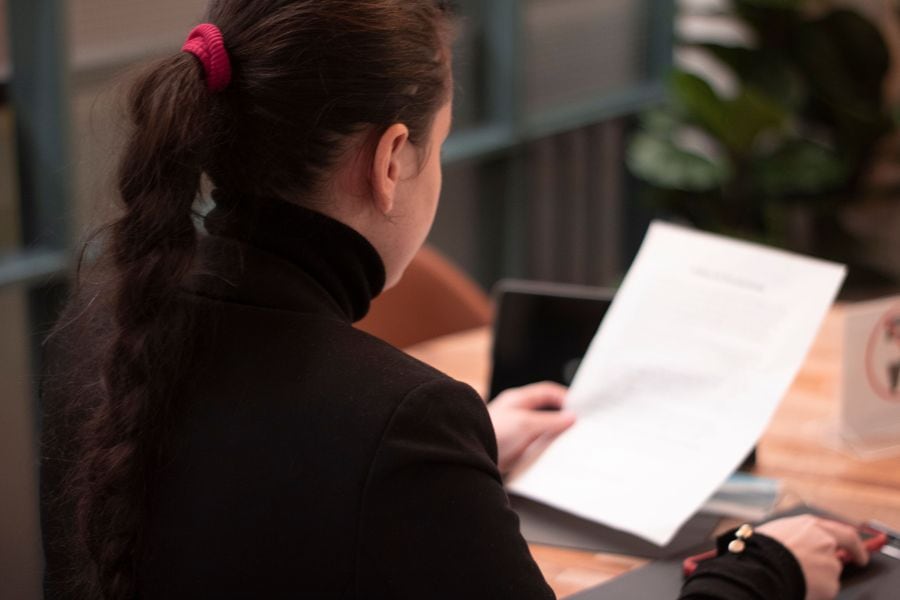 Woman reading a rental notice document at a desk, reviewing required NSW notice guidelines.