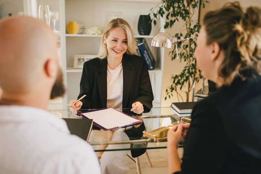 Happy couple meeting with a real estate agent in a bright office. 