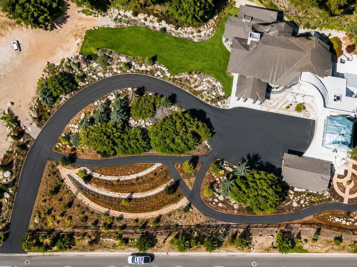 Aerial drone view of luxury asphalt driveway and landscaping at Utah estate