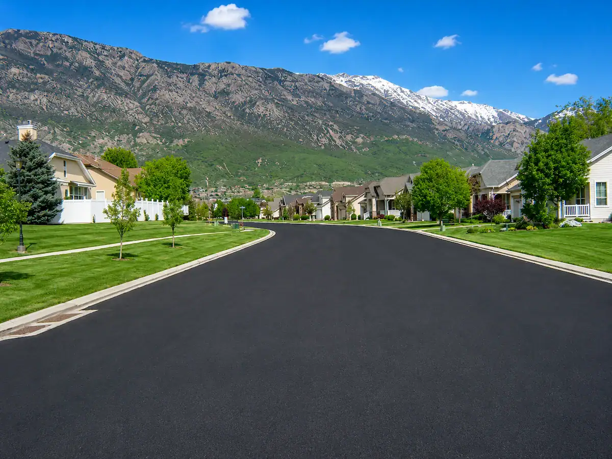 Freshly paved residential asphalt roadway with mountain views in Utah neighborhood