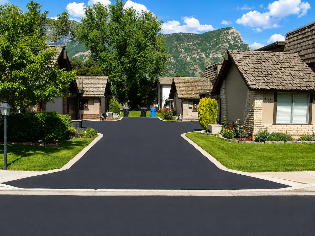 Freshly sealcoated residential driveway in a Utah neighborhood with mountain backdrop