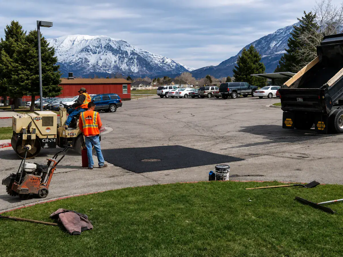 Commercial asphalt patching repair project in Utah parking lot with mountains in the background