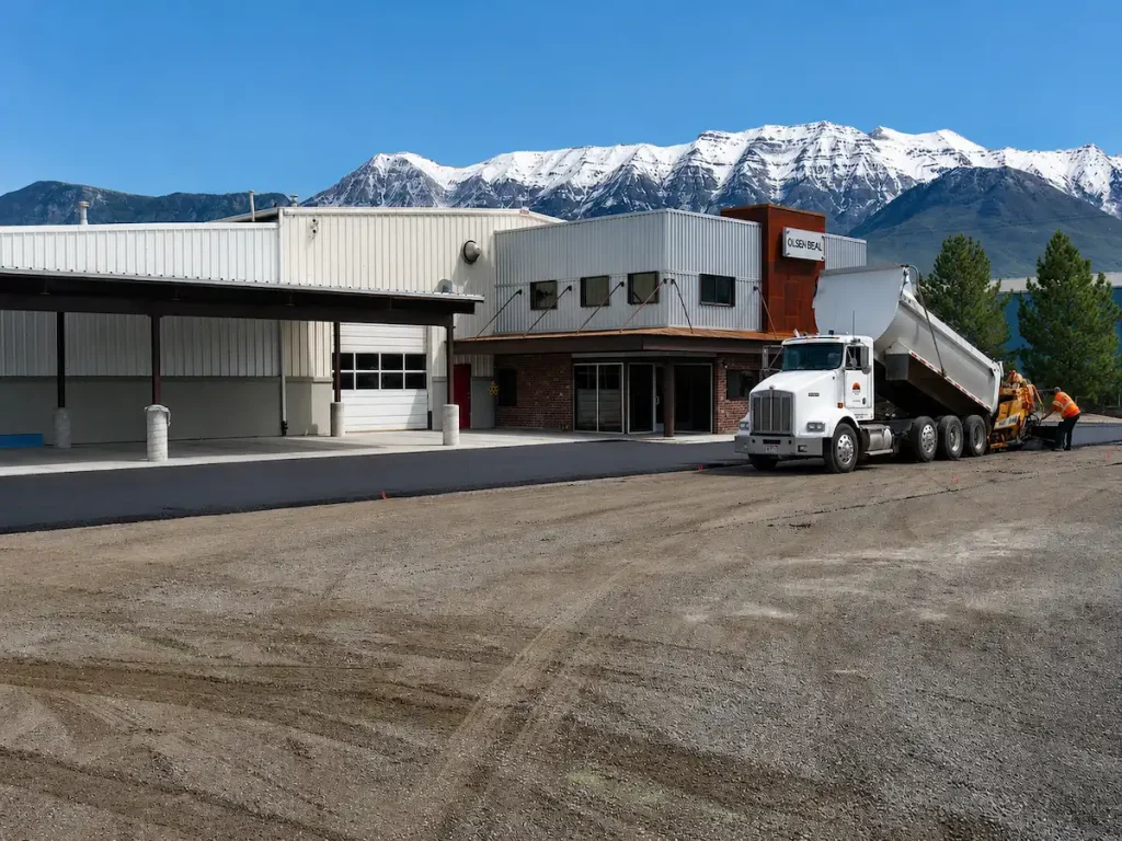 Commercial grading and site preparation project in Utah with fresh asphalt paving and mountain views.