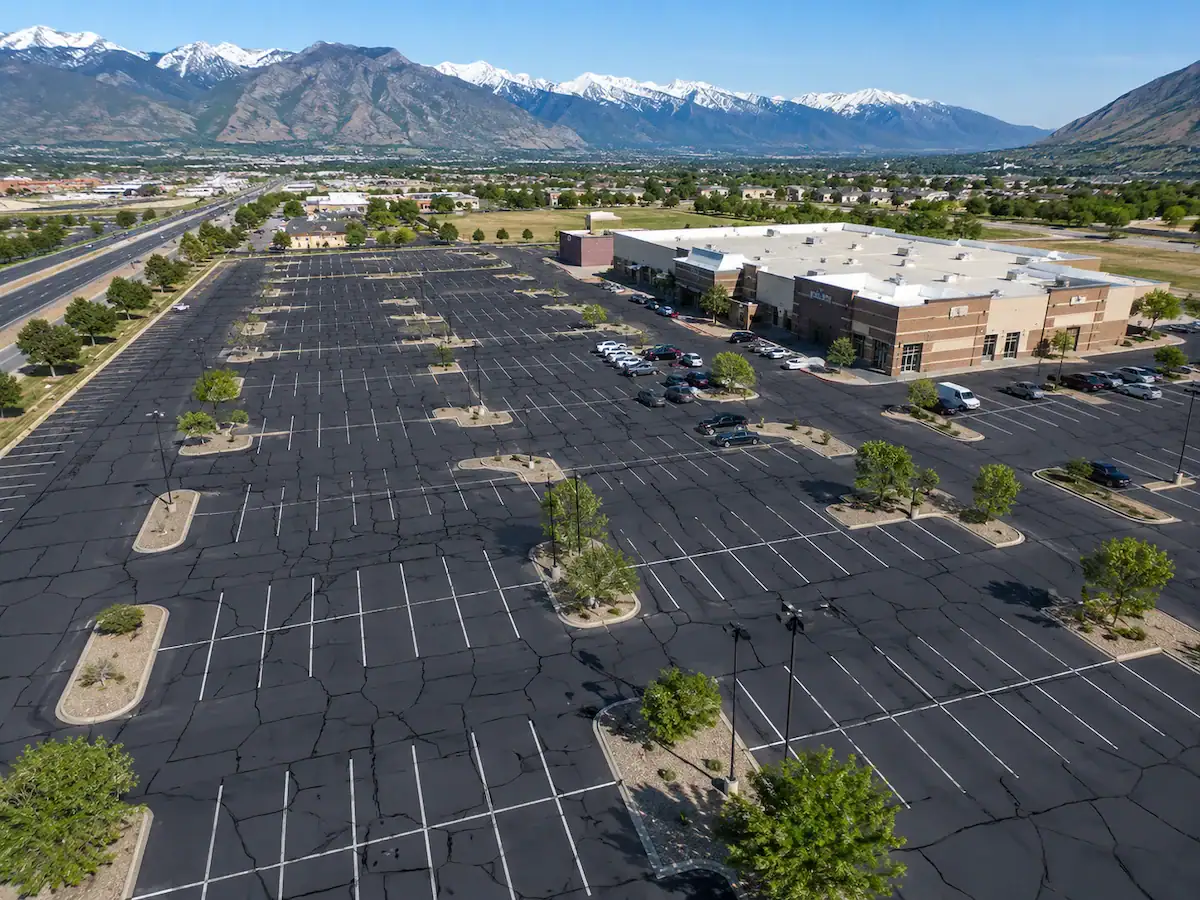 Aerial drone view of a Utah commercial parking lot showing extensive asphalt crack sealing and pavement maintenance.