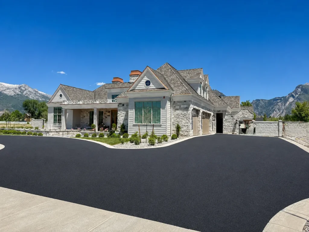 Freshly paved custom asphalt driveway at a luxury residential home in Utah with mountain views in the background.